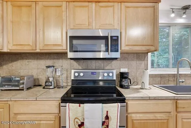 a kitchen with granite countertop a stove sink and cabinets