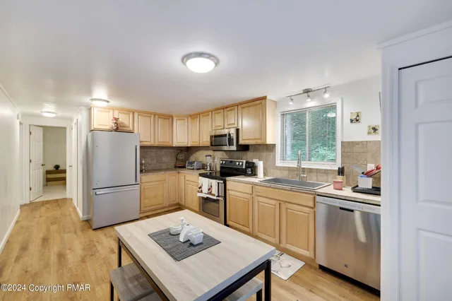 a kitchen with a sink a counter top space stainless steel appliances and cabinets