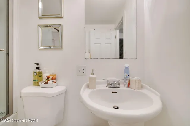 a bathroom with a sink a toilet and mirror