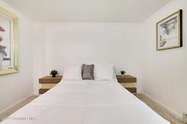 a bedroom with a bed and a painting on the wall