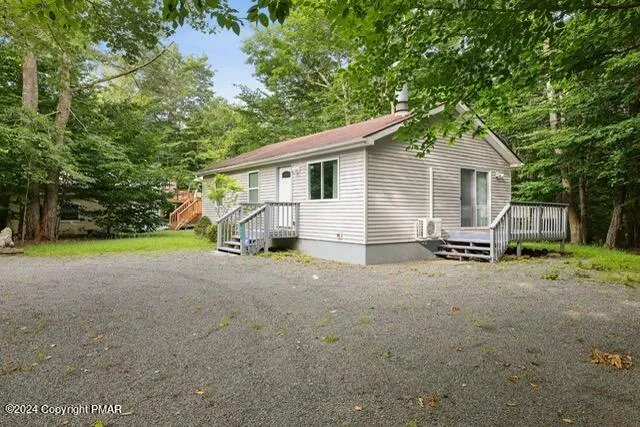 a view of a house with backyard and a tree