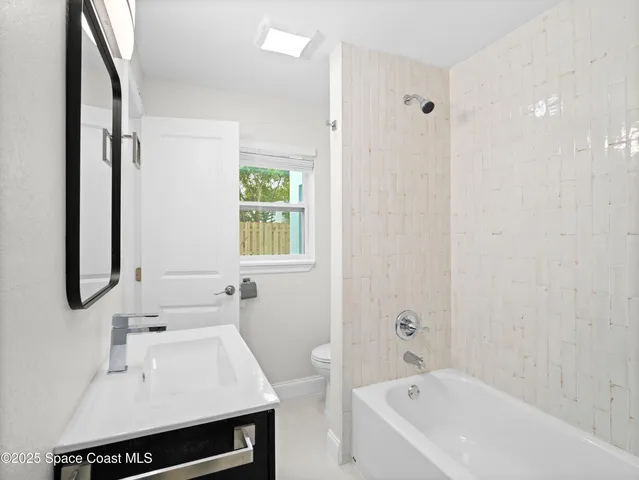 a bathroom with a bathtub a sink a toilet and a mirror