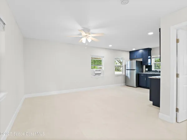 a view of an empty room with a kitchen