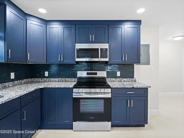 a kitchen with granite countertop wooden cabinets and a stove top oven