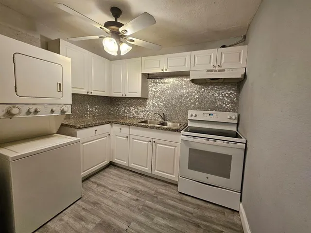 a kitchen with stainless steel appliances white cabinets and a sink