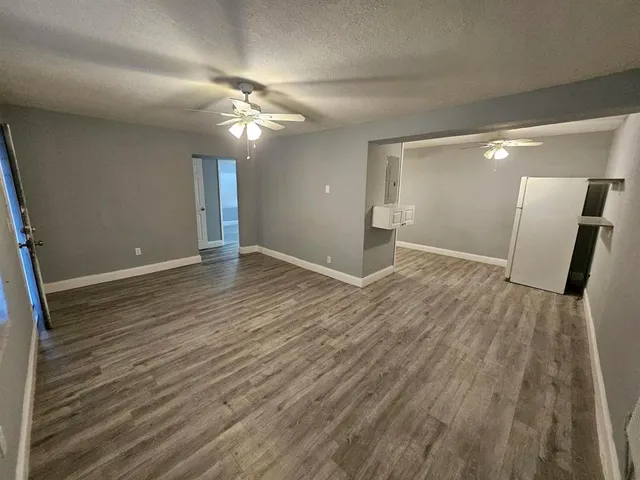 a view of an empty room with wooden floor