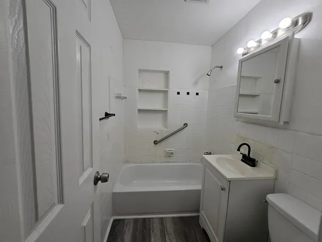 a bathroom with a bathtub a sink a toilet and a mirror