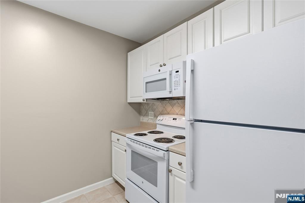 905 River Road, Unit 218 Edgewater, NJ 07020 - Photo 10 of 23 a kitchen with cabinets and a stove