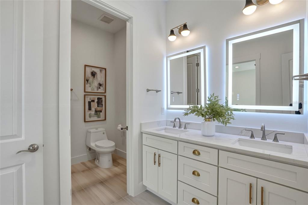 534 Crystal Drive Madeira Beach, FL 33708 - Photo 44 of 68 a bathroom with a granite countertop sink toilet and a mirror