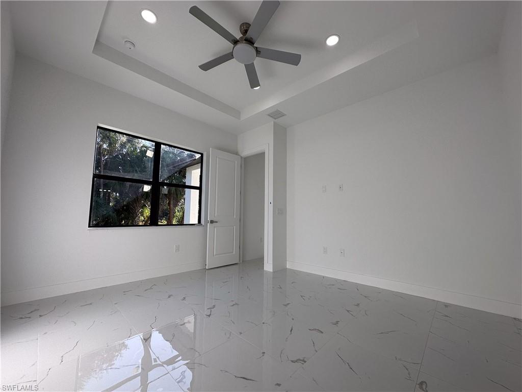 1028 19th Street Southwest Naples, FL 34117 - Photo 16 of 50 an empty room with wooden floor and windows
