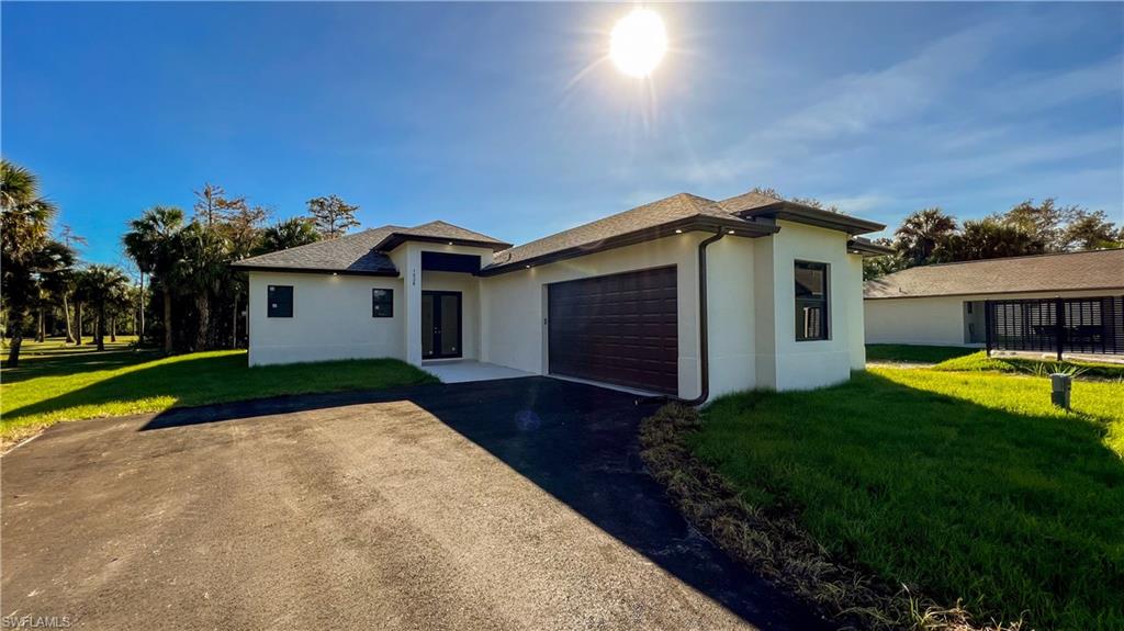 1028 19th Street Southwest Naples, FL 34117 - Photo 2 of 50 a front view of a house with yard and green space