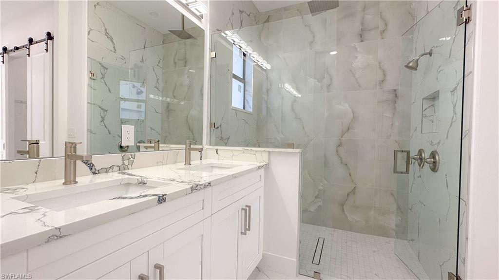 1028 19th Street Southwest Naples, FL 34117 - Photo 23 of 50 a bathroom with a double vanity sink mirror and shower