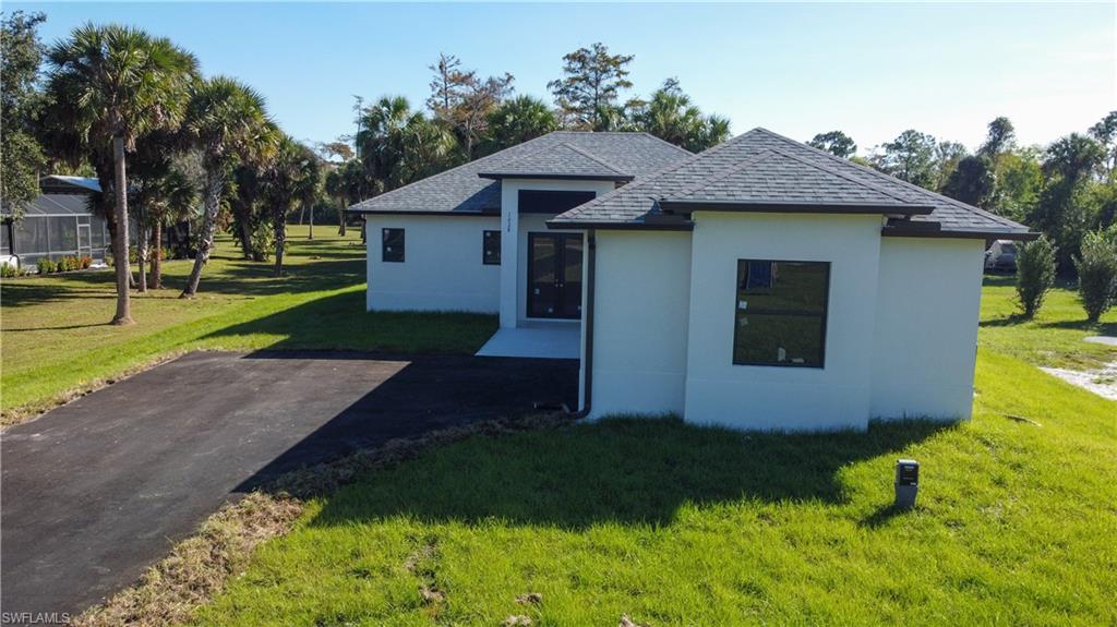 1028 19th Street Southwest Naples, FL 34117 - Photo 3 of 50 a front view of a house with a yard