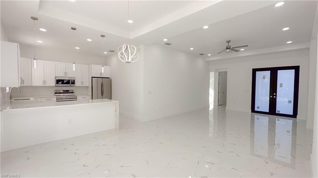 1028 19th Street Southwest Naples, FL 34117 - Photo 7 of 50 a large white kitchen with kitchen island a sink stainless steel appliances and cabinets