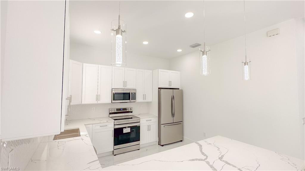 1028 19th Street Southwest Naples, FL 34117 - Photo 9 of 50 a kitchen with a refrigerator and a stove
