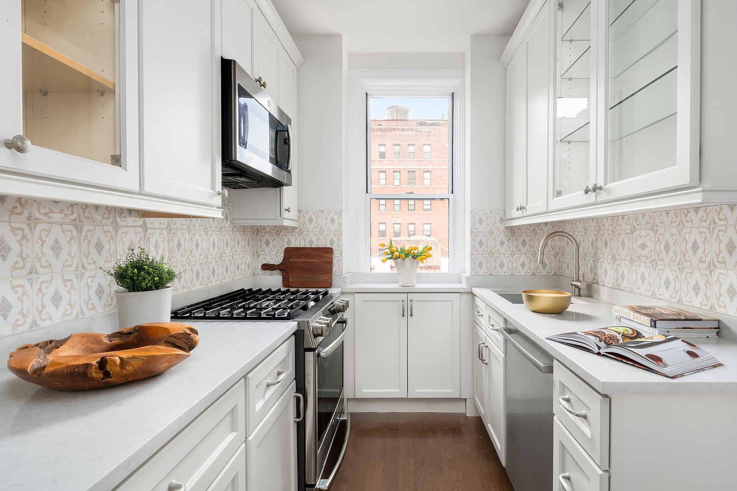 131 East 93rd Street, Unit 7A Manhattan, NY 10128 - Photo 4 of 8 a kitchen with stainless steel appliances a stove a sink and a white cabinets