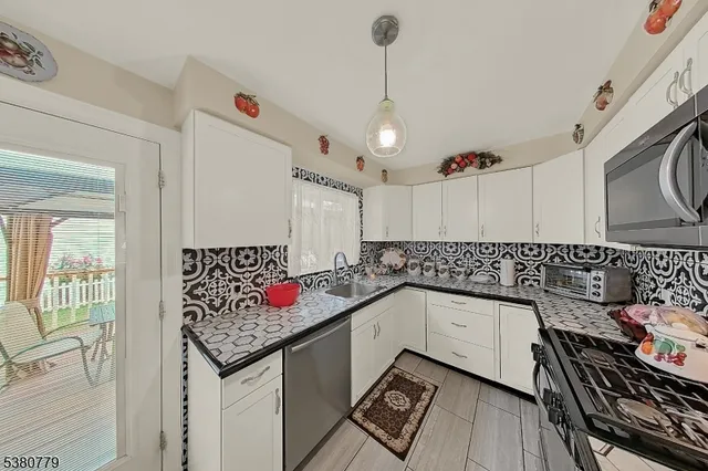 a kitchen with stainless steel appliances granite countertop a sink stove and cabinets