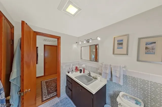 a bathroom with sink a mirror a toilet and vanity