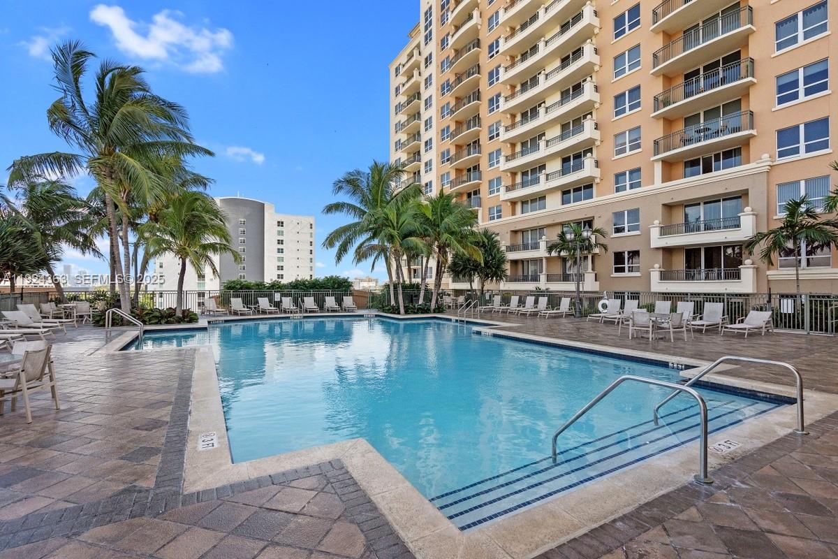 3232 Southwest 22nd Street, Unit 905 Miami, FL 33145 - Photo 13 of 24 a swimming pool with outdoor seating and yard