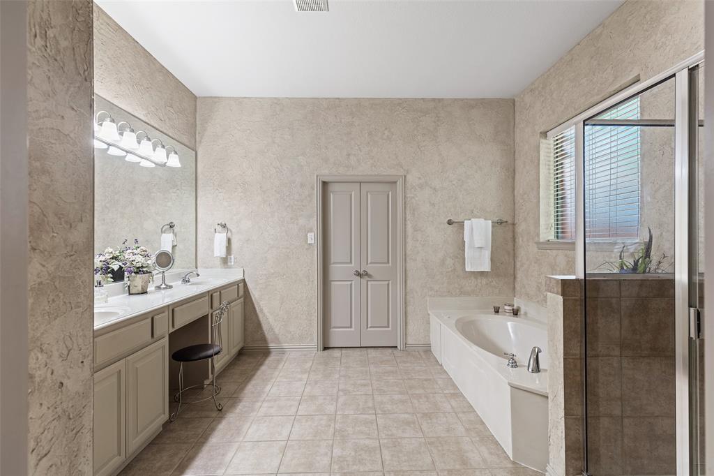 1217 Windmere Way Allen, TX 75013 - Photo 25 of 38 Complete with a soaking tub and separate glass-enclosed shower, the luxurious bath creates a calming escape just steps from the primary suite.