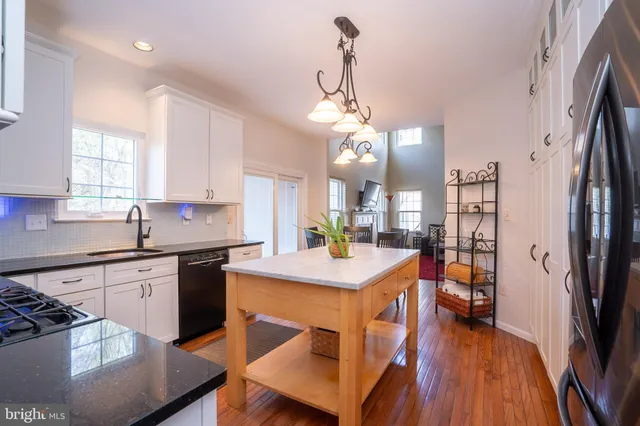 a kitchen with stainless steel appliances granite countertop a sink a stove a microwave and wooden cabinets