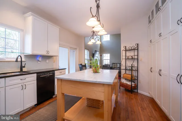 a view of a hallway to a livingroom with furniture wooden floor and windows