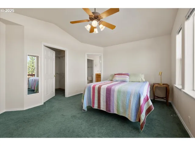 a bedroom with a bed and a ceiling fan