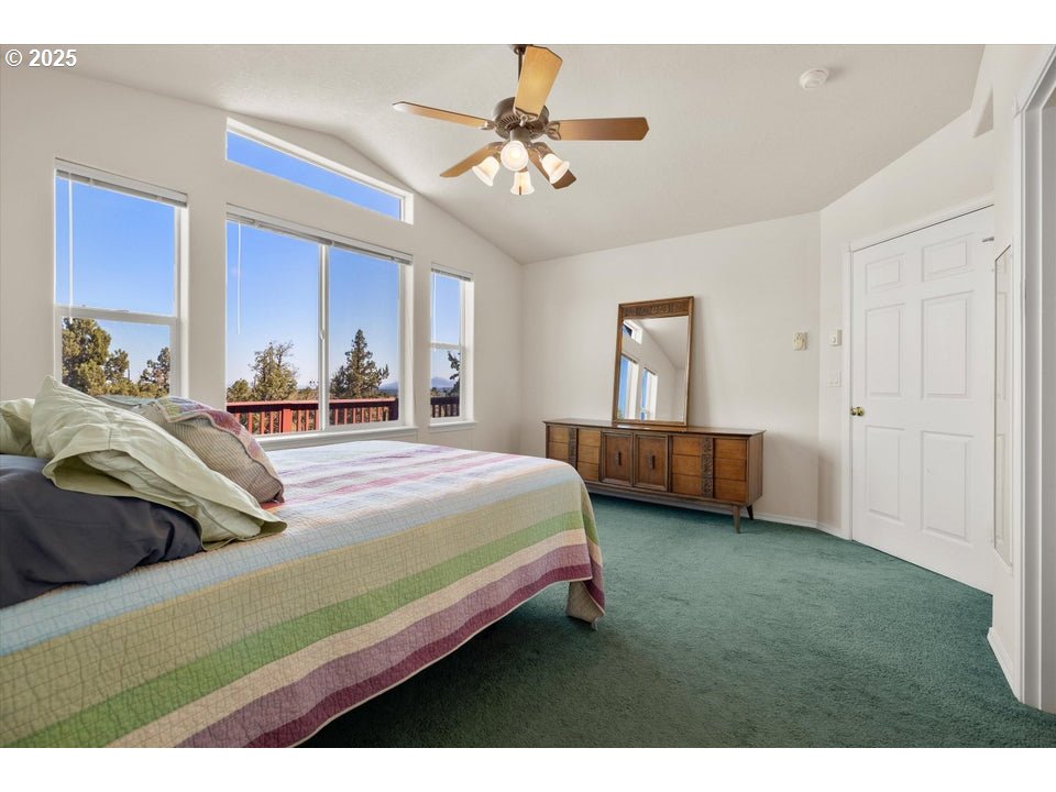 21085 Arid Avenue Bend, OR 97703 - Photo 17 of 45 a bedroom with a bed and a chandelier