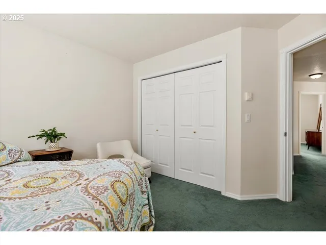 a bedroom with a bed and a painting on the wall