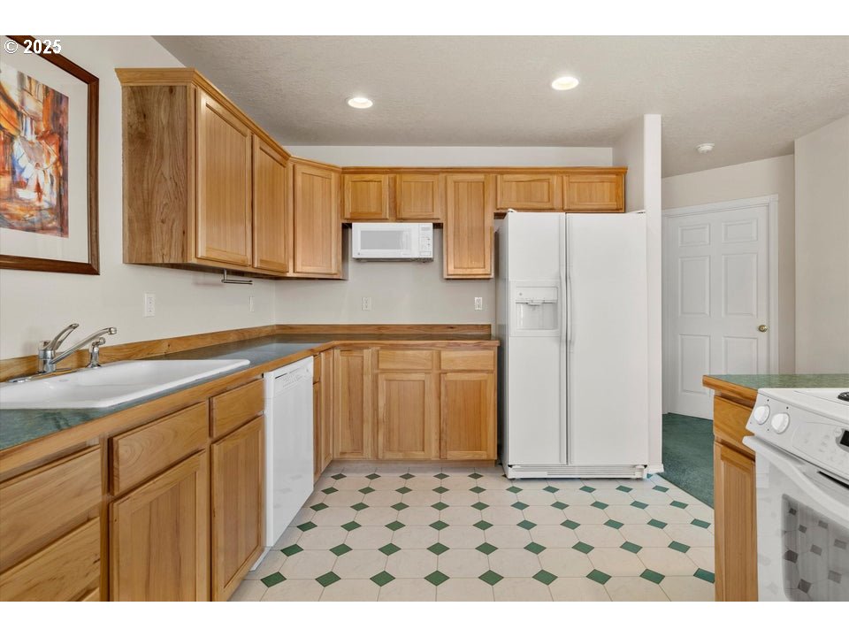 21085 Arid Avenue Bend, OR 97703 - Photo 9 of 45 a kitchen with a refrigerator and a sink