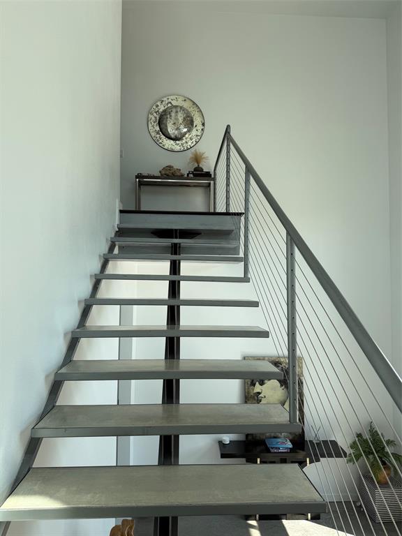 13023 Copenhill Road Dallas, TX 75240 - Photo 4 of 35 Floating staircase with metal treads, cable railing, and a landing