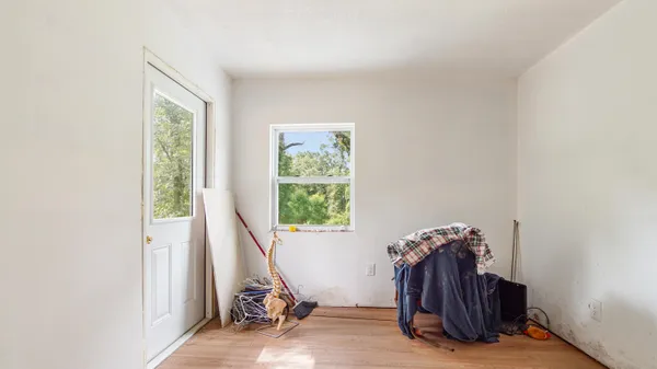 a view of a hall with wooden floor and furniture