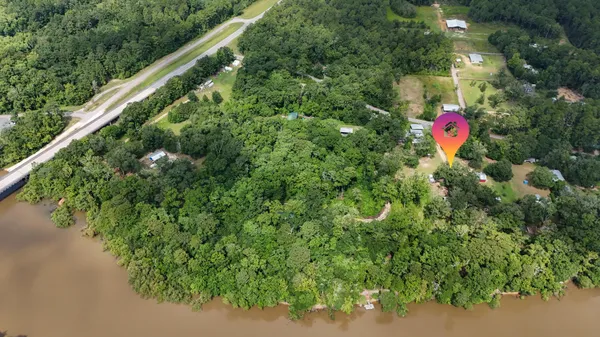 an aerial view of a houses with a yard and lake view