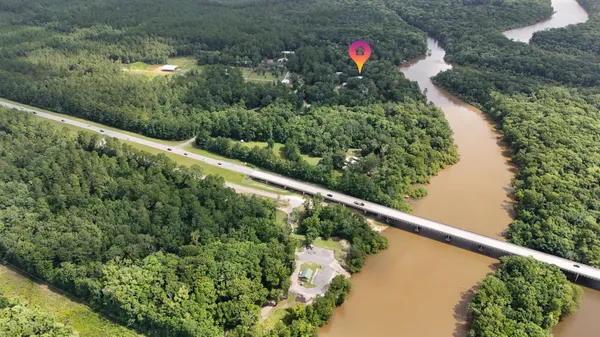 an aerial view of residential house with outdoor space and trees all around