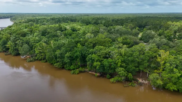 an aerial view of residential house with outdoor space and trees all around