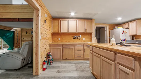 a kitchen with kitchen island granite countertop a sink cabinets and stainless steel appliances