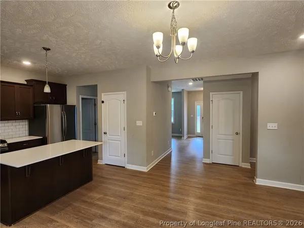 a view of a kitchen with a refrigerator and a wooden floor