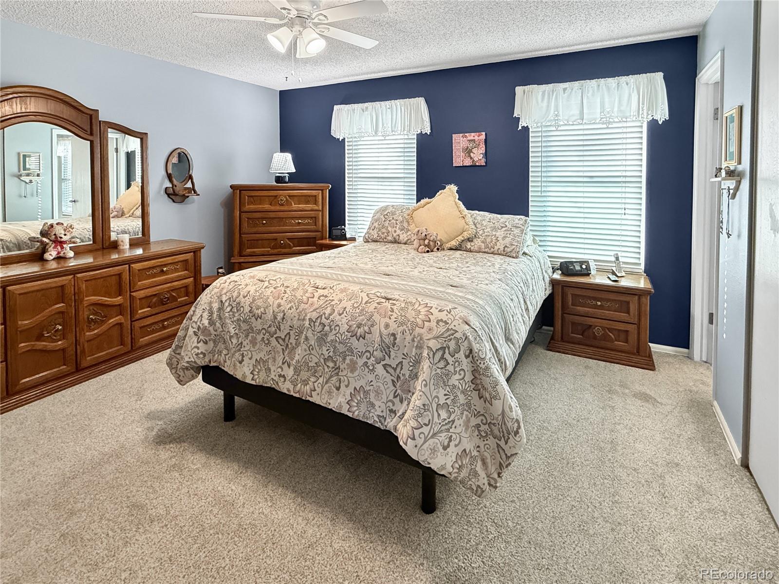4386 South Xenophon Way Morrison, CO 80465 - Photo 18 of 38 a bedroom with a bed and dresser with mirror