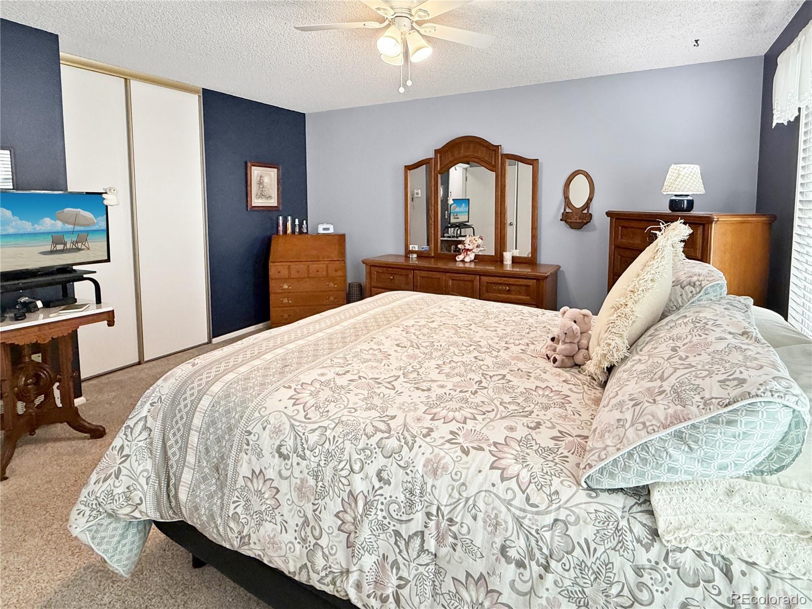 4386 South Xenophon Way Morrison, CO 80465 - Photo 19 of 38 a bedroom with a bed and a chandelier