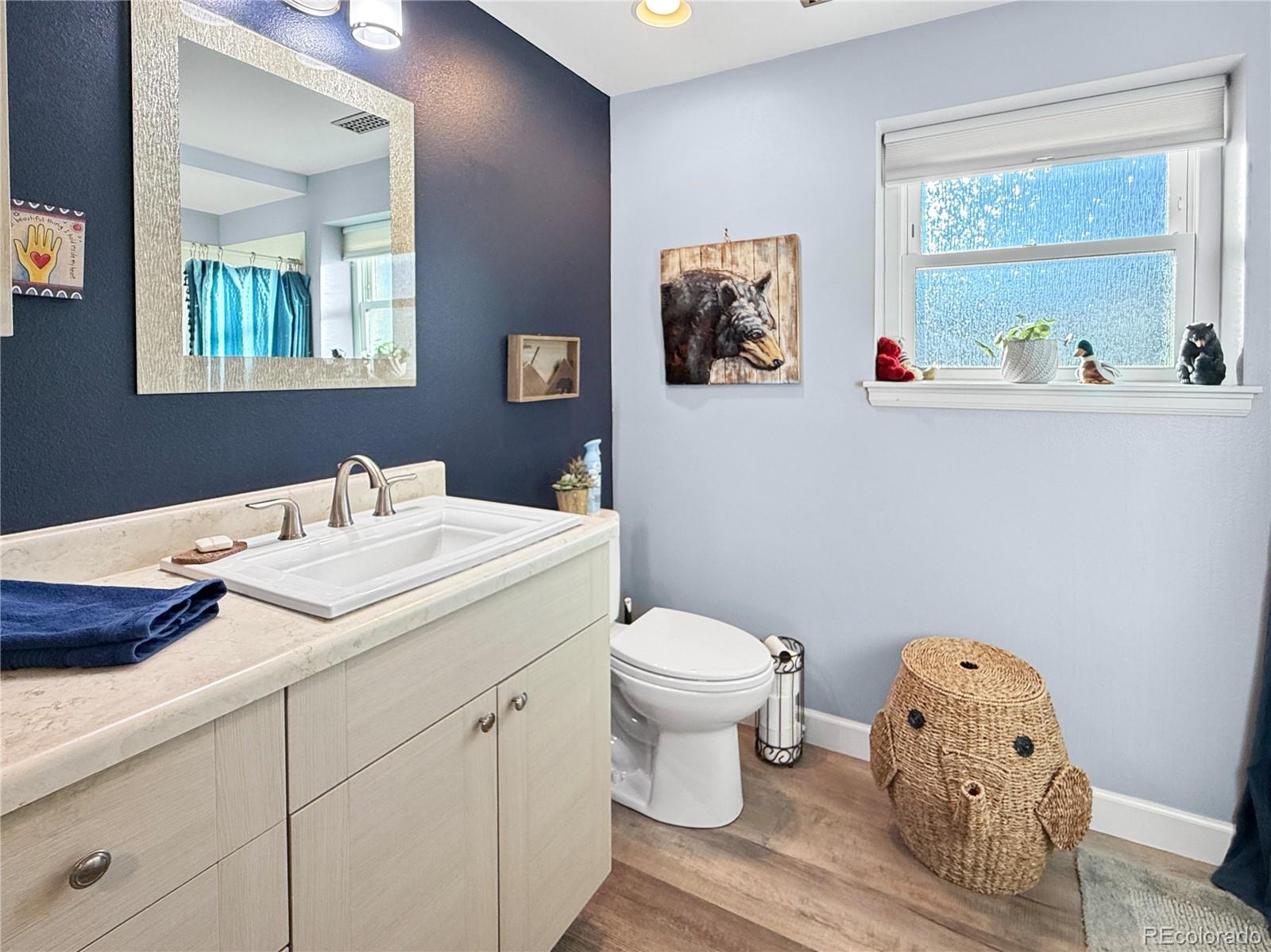 4386 South Xenophon Way Morrison, CO 80465 - Photo 25 of 38 a bathroom with a toilet sink and mirror
