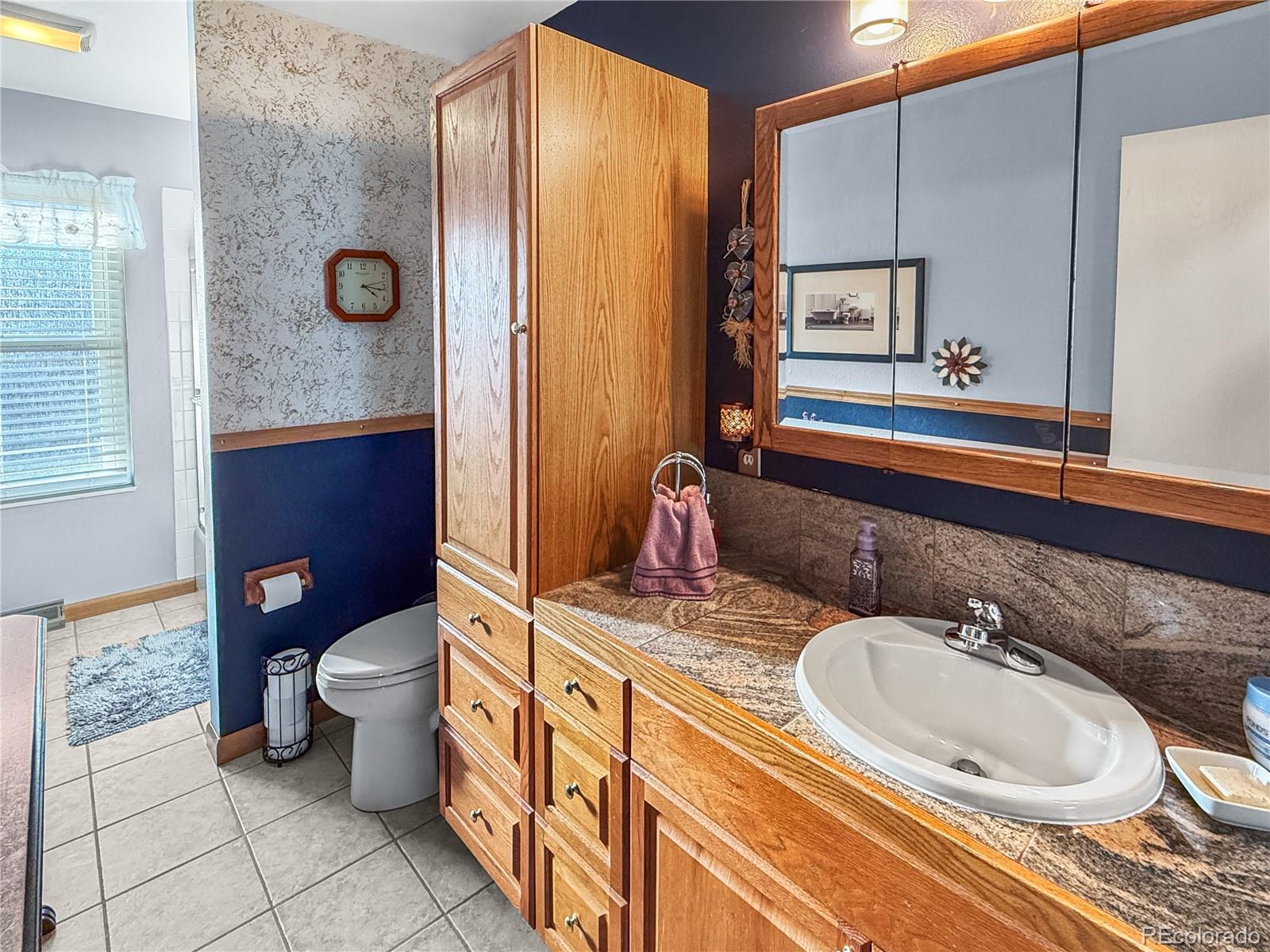 4386 South Xenophon Way Morrison, CO 80465 - Photo 28 of 38 a bathroom with a granite countertop sink and a mirror
