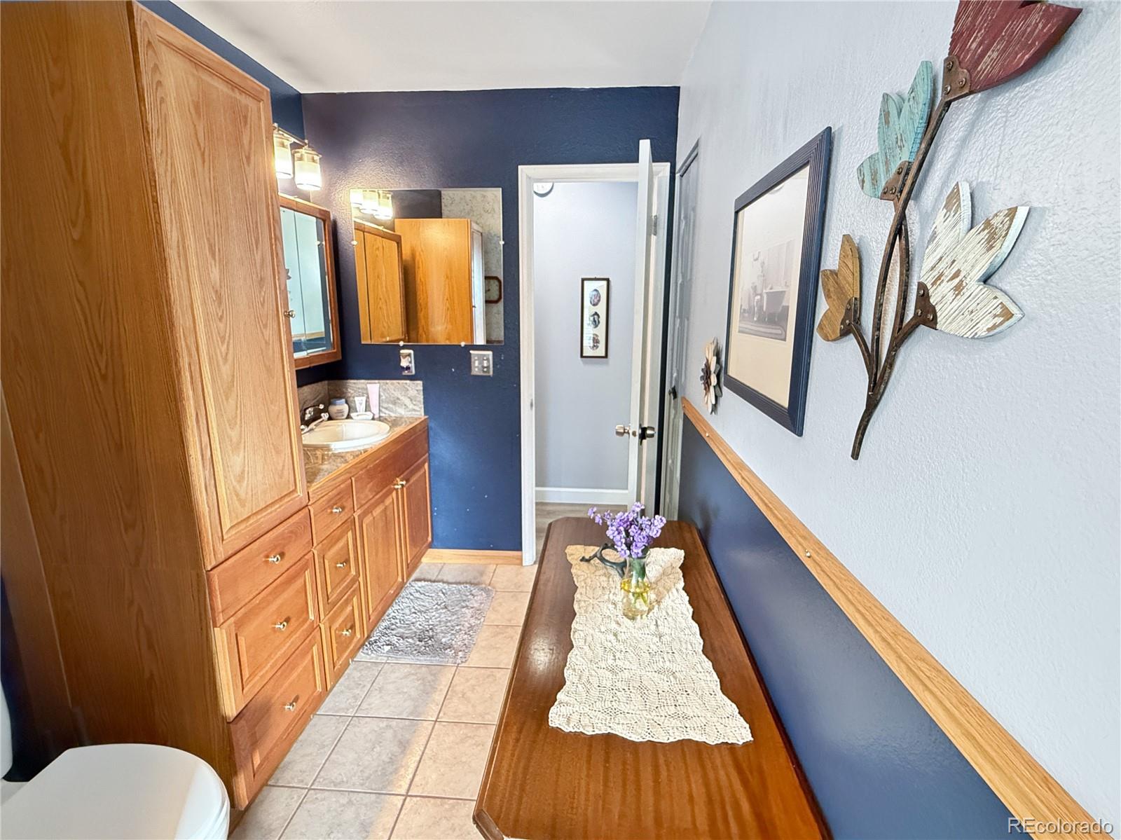 4386 South Xenophon Way Morrison, CO 80465 - Photo 30 of 38 a bathroom with a sink a mirror and a bathtub