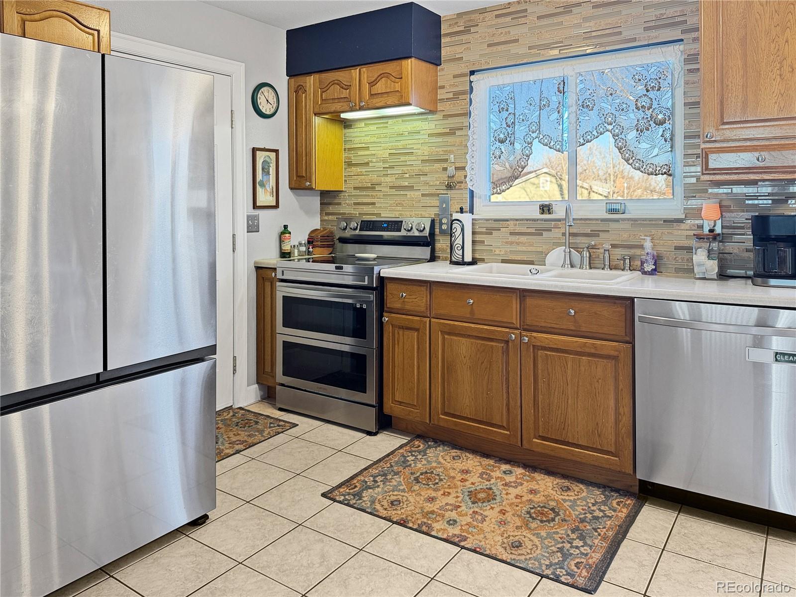 4386 South Xenophon Way Morrison, CO 80465 - Photo 9 of 38 a kitchen with stainless steel appliances a stove and refrigerator