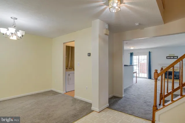 wooden floor in an empty room with a chandelier fan