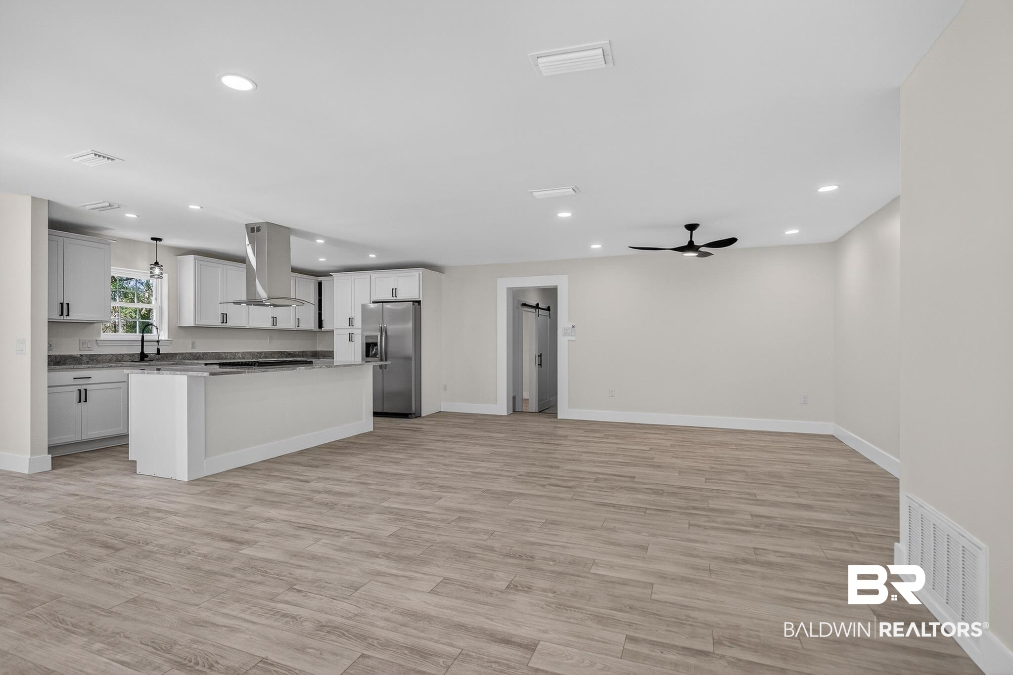 10650 Old Pascagoula Road Theodore, AL 36582 - Photo 75 of 77 Kitchen with a kitchen island, open floor plan, stainless steel fridge, island range hood, and light wood-style flooring