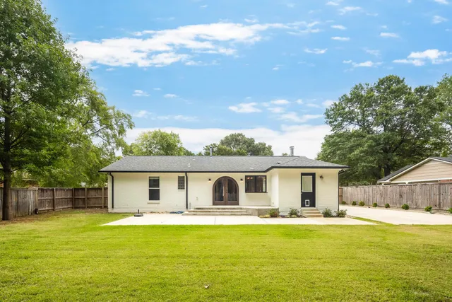 a front view of house with swimming pool and green space
