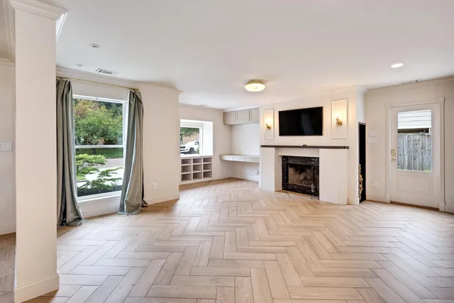 a view of an empty room with a fireplace and a window