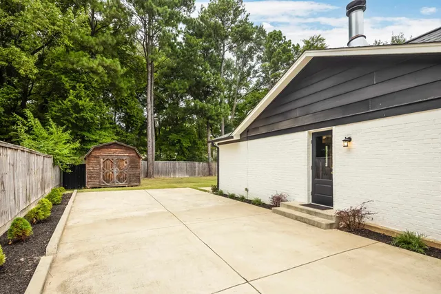 a patio with table and chairs and potted plants