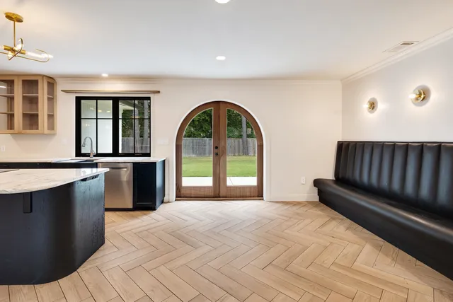 a view of a kitchen with a sink and dishwasher with wooden floor