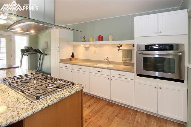 10265 Shoup Road Colorado Springs, CO 80908 - Photo 2 of 25 Kitchen includes an island with granite top and 5-burner gas cooktop